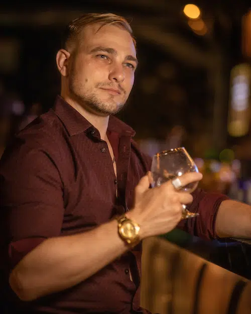 guy looking while holding a glass of wine