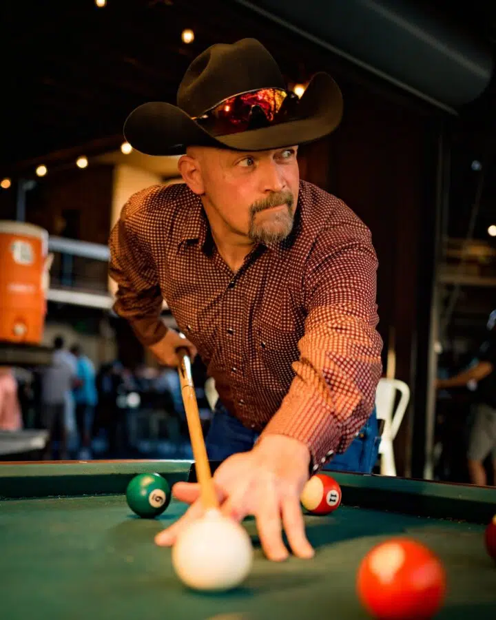 guy with cowboy hat playing pool