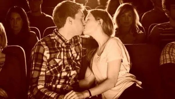 Young couple kissing at movie theatre