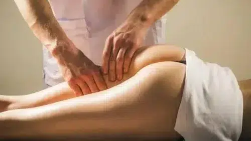 massage therapist massaging woman her buttocks